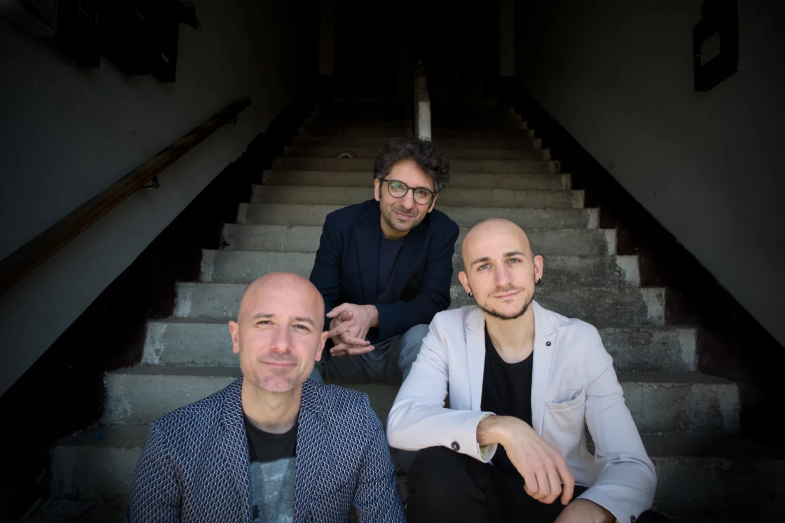 I tre musicisti di The Blue Prospective fotografati su una scalinata